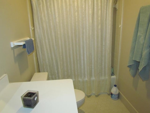 bathroom featuring shower / bath combination with curtain, toilet, and tile patterned floors