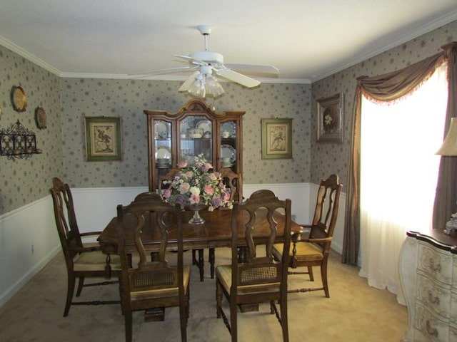 dining room featuring crown molding, light carpet, and ceiling fan