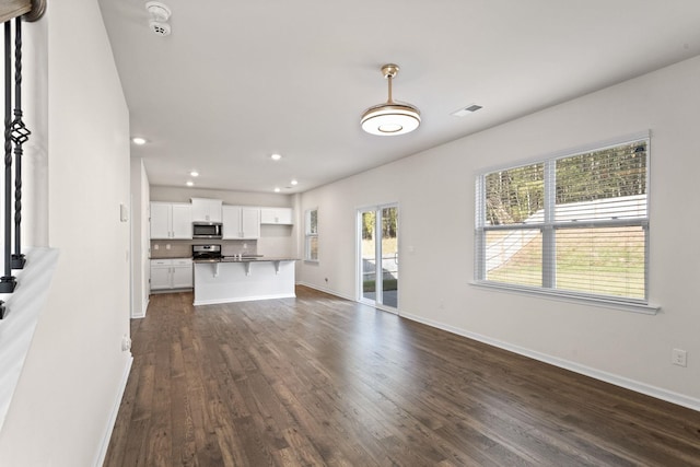 unfurnished living room with dark hardwood / wood-style flooring