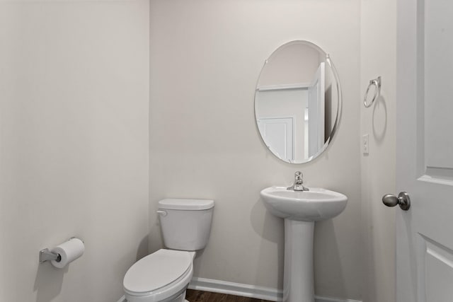 bathroom featuring toilet and wood-type flooring