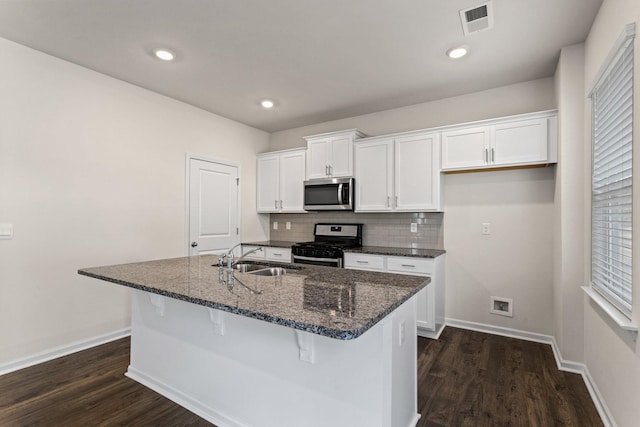 kitchen with stainless steel appliances, sink, an island with sink, and white cabinets