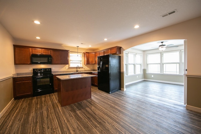 kitchen with sink, black appliances, ceiling fan, decorative light fixtures, and dark hardwood / wood-style flooring