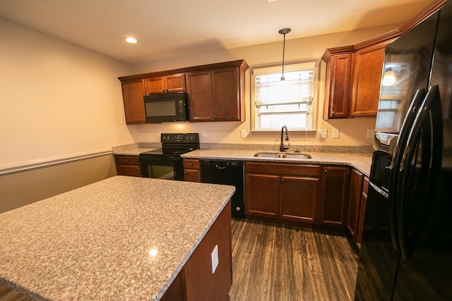 kitchen with dark hardwood / wood-style flooring, black appliances, sink, and light stone counters