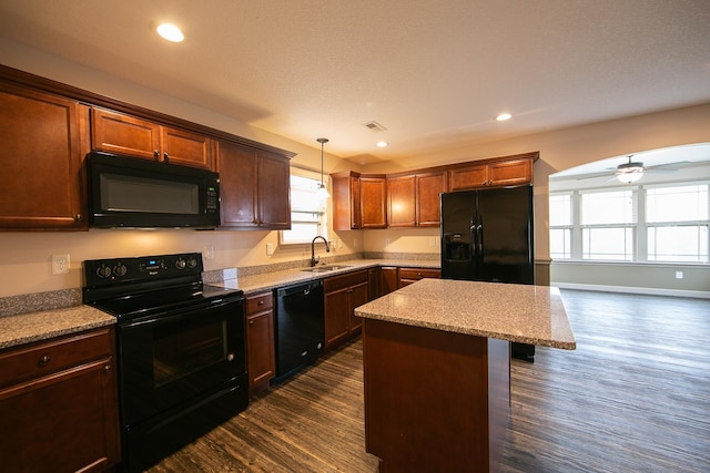 kitchen with black appliances, a wealth of natural light, sink, and a center island