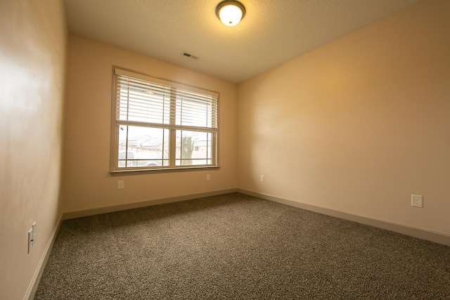 carpeted empty room with a textured ceiling