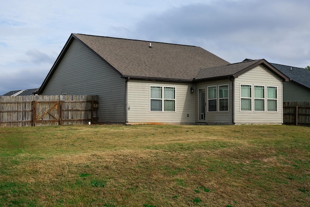 rear view of property featuring a yard