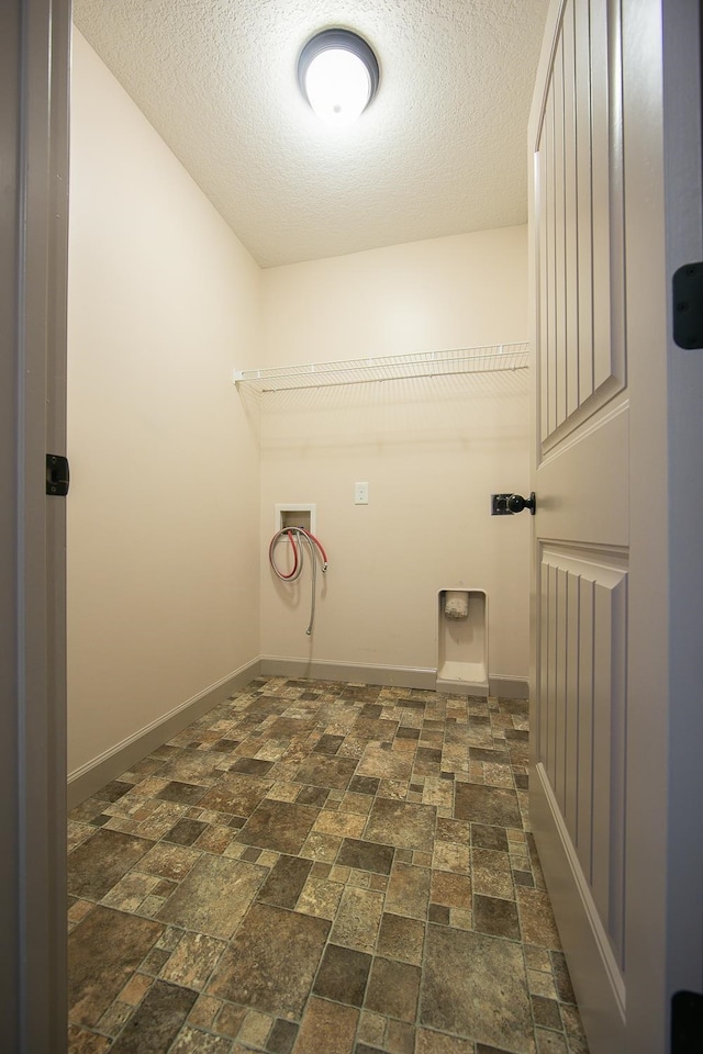 laundry area with a textured ceiling and hookup for a washing machine