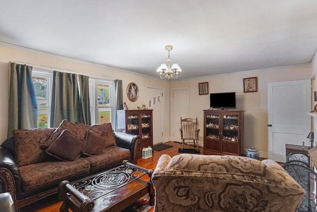 living room with an inviting chandelier, hardwood / wood-style flooring, and crown molding