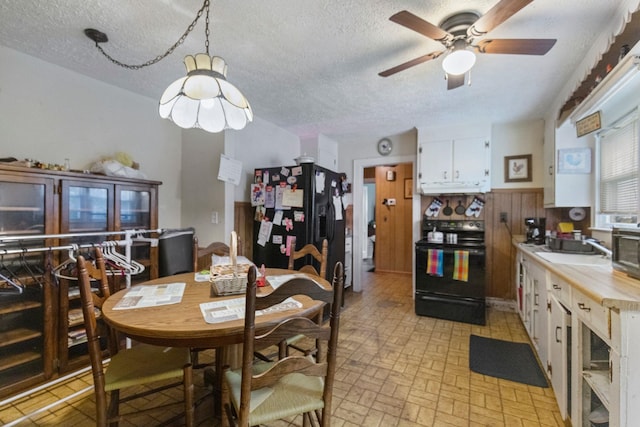 dining area with a textured ceiling, ceiling fan, and sink