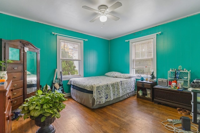 bedroom with ceiling fan, multiple windows, and wood-type flooring