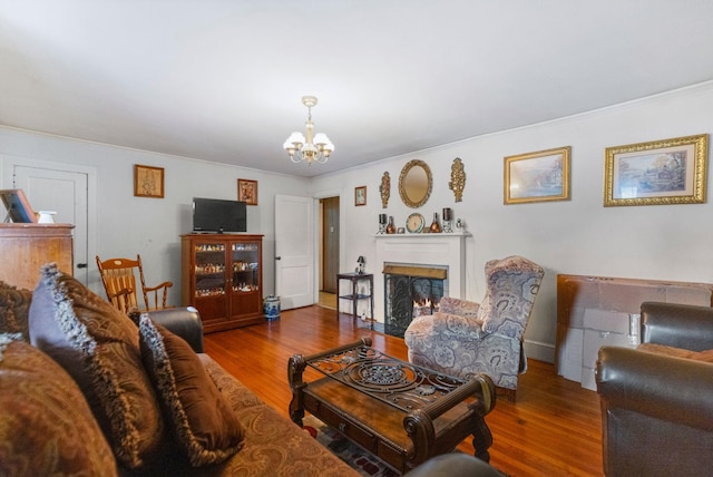 living room featuring dark wood-type flooring, a notable chandelier, and crown molding