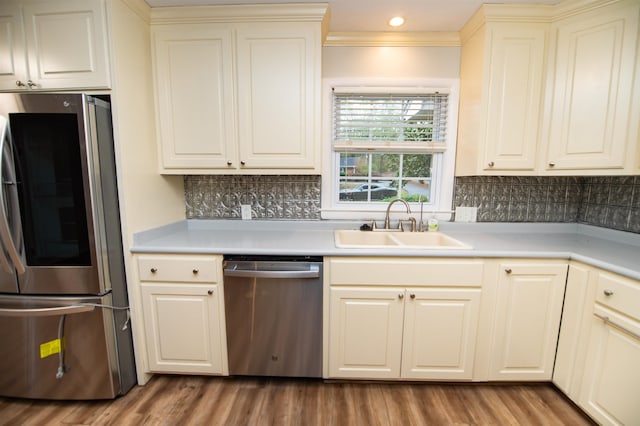 kitchen featuring tasteful backsplash, appliances with stainless steel finishes, sink, and hardwood / wood-style flooring