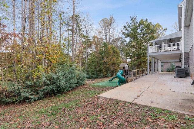 view of yard featuring central air condition unit, a playground, and a carport