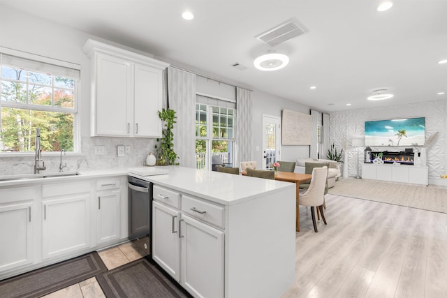 kitchen featuring white cabinetry, light hardwood / wood-style flooring, sink, and dishwasher