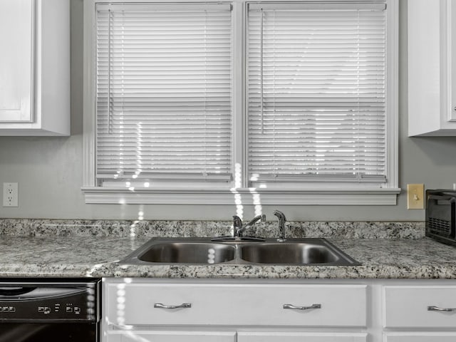 room details with black dishwasher, white cabinetry, and sink