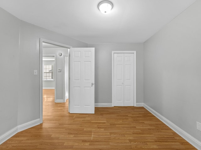 unfurnished bedroom with a closet and light hardwood / wood-style flooring