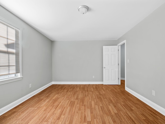 empty room with plenty of natural light and light hardwood / wood-style flooring