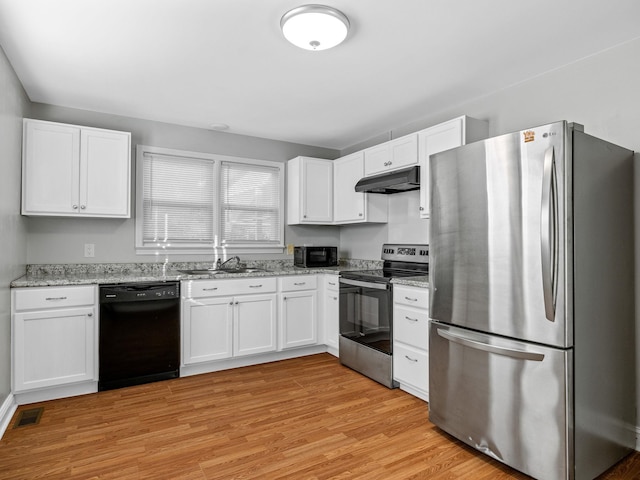 kitchen featuring light stone counters, white cabinets, black appliances, sink, and light hardwood / wood-style flooring