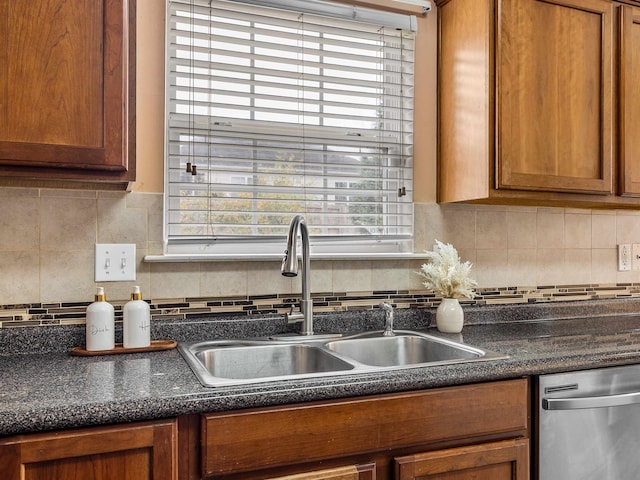 kitchen with tasteful backsplash, stainless steel dishwasher, and sink