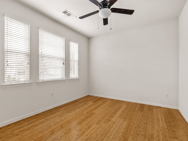 spare room featuring light hardwood / wood-style floors, a healthy amount of sunlight, and ceiling fan