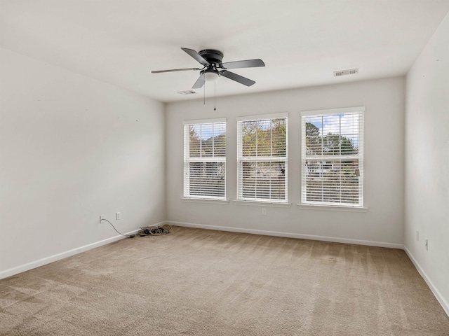 spare room with a wealth of natural light, ceiling fan, and carpet floors