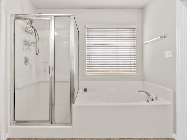 bathroom featuring shower with separate bathtub