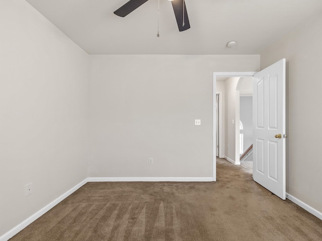 carpeted spare room featuring ceiling fan