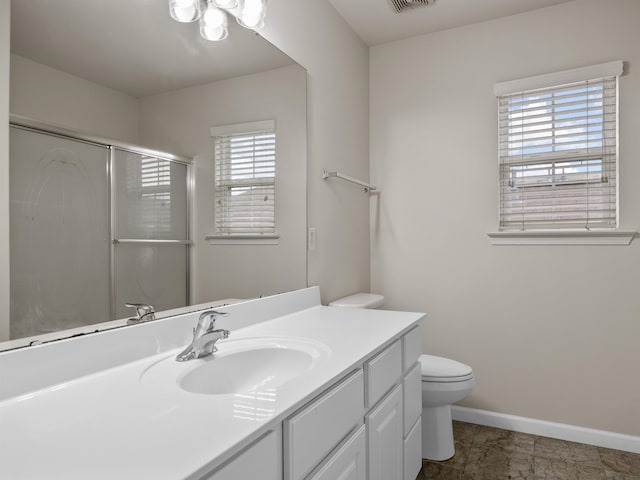 bathroom with toilet, vanity, an enclosed shower, and plenty of natural light