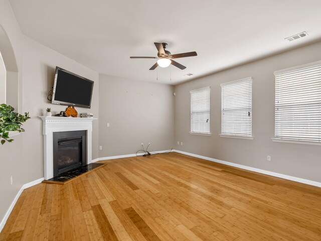 unfurnished living room with wood-type flooring and ceiling fan