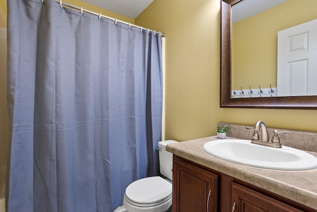 bathroom featuring curtained shower, vanity, and toilet