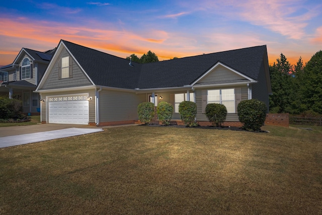 view of front of home with a garage and a lawn