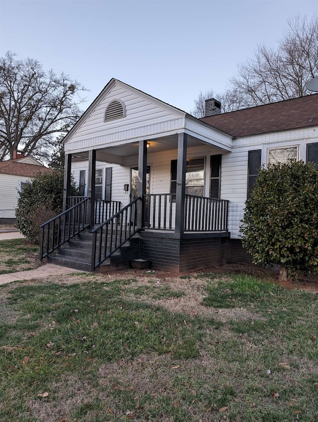 view of front of property with a front yard and covered porch