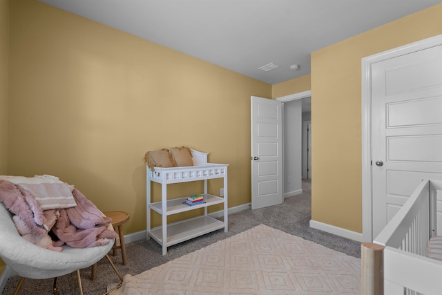 bedroom featuring light carpet and a nursery area