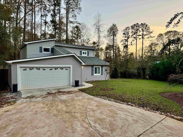 front of property featuring a lawn and a garage