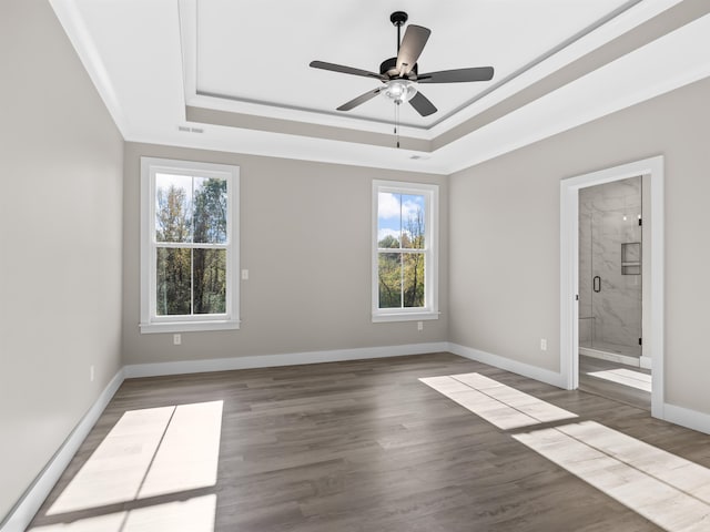 unfurnished bedroom with hardwood / wood-style floors, multiple windows, ceiling fan, and connected bathroom