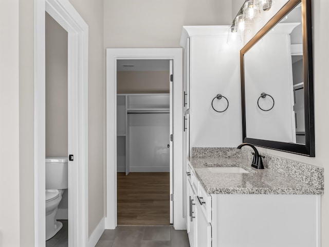 bathroom featuring toilet, vanity, and hardwood / wood-style flooring