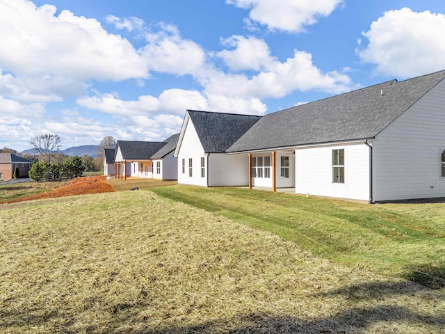 rear view of house featuring a yard