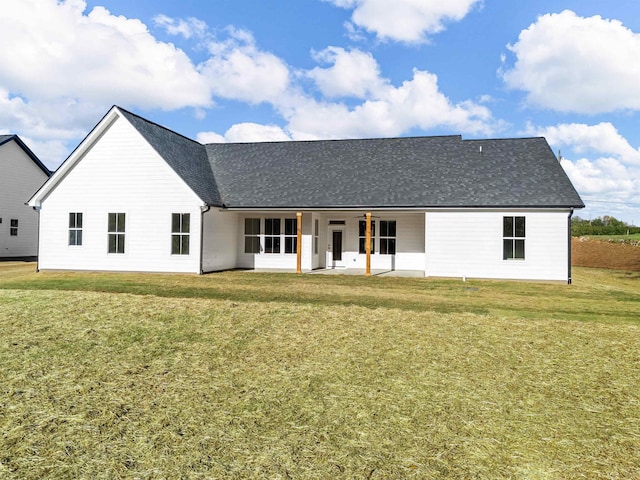 rear view of house featuring ceiling fan, a yard, and a patio area