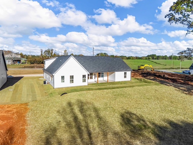 rear view of house featuring a yard