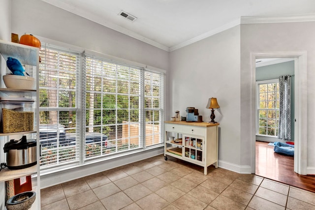 entryway featuring light tile patterned floors and crown molding