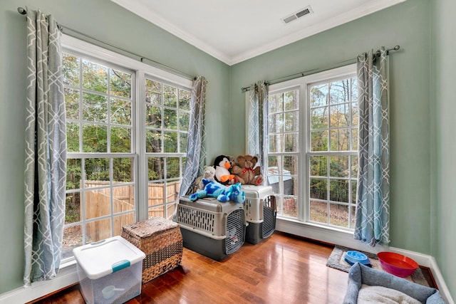 interior space with ornamental molding and hardwood / wood-style floors