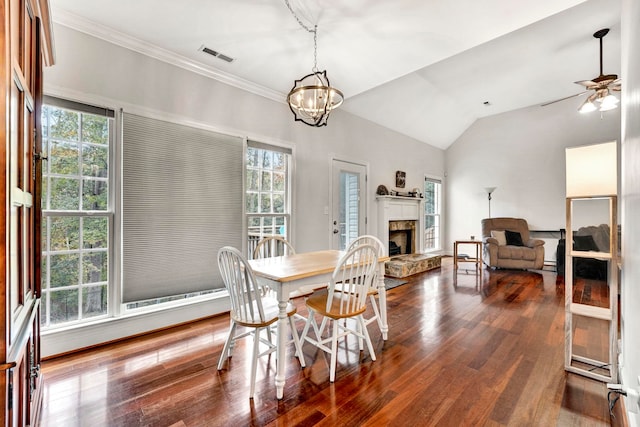 dining space featuring ceiling fan with notable chandelier, a wealth of natural light, dark hardwood / wood-style floors, and lofted ceiling