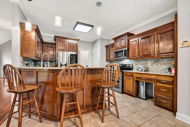 kitchen featuring tasteful backsplash, kitchen peninsula, light stone countertops, a kitchen breakfast bar, and stainless steel appliances