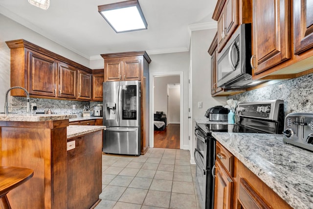 kitchen featuring stainless steel appliances, tasteful backsplash, light stone counters, light tile patterned floors, and crown molding