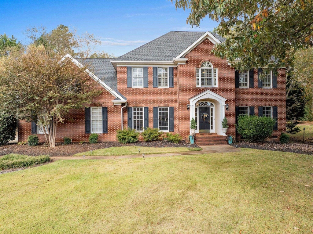 colonial inspired home featuring a front lawn