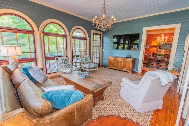 living room with light hardwood / wood-style floors, an inviting chandelier, and a healthy amount of sunlight