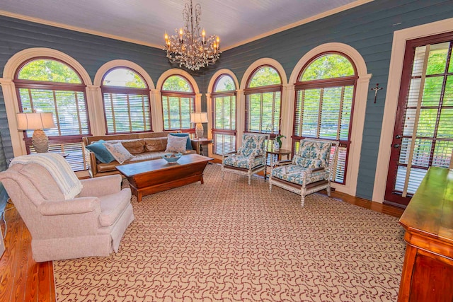 living room with a chandelier, light hardwood / wood-style floors, and crown molding