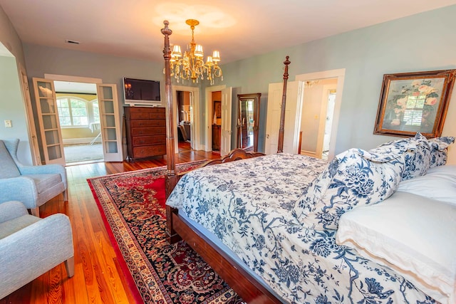 bedroom with wood-type flooring and a notable chandelier