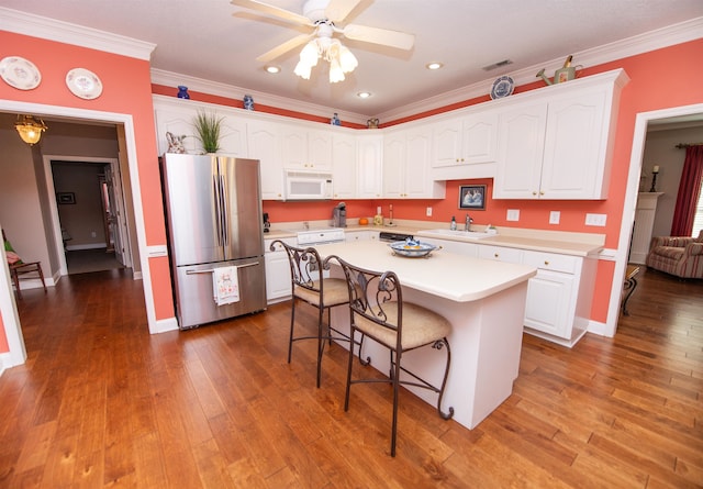 kitchen featuring stainless steel refrigerator, white cabinetry, crown molding, and a center island