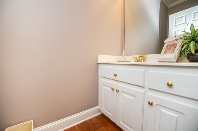 bathroom with vanity, hardwood / wood-style flooring, and crown molding